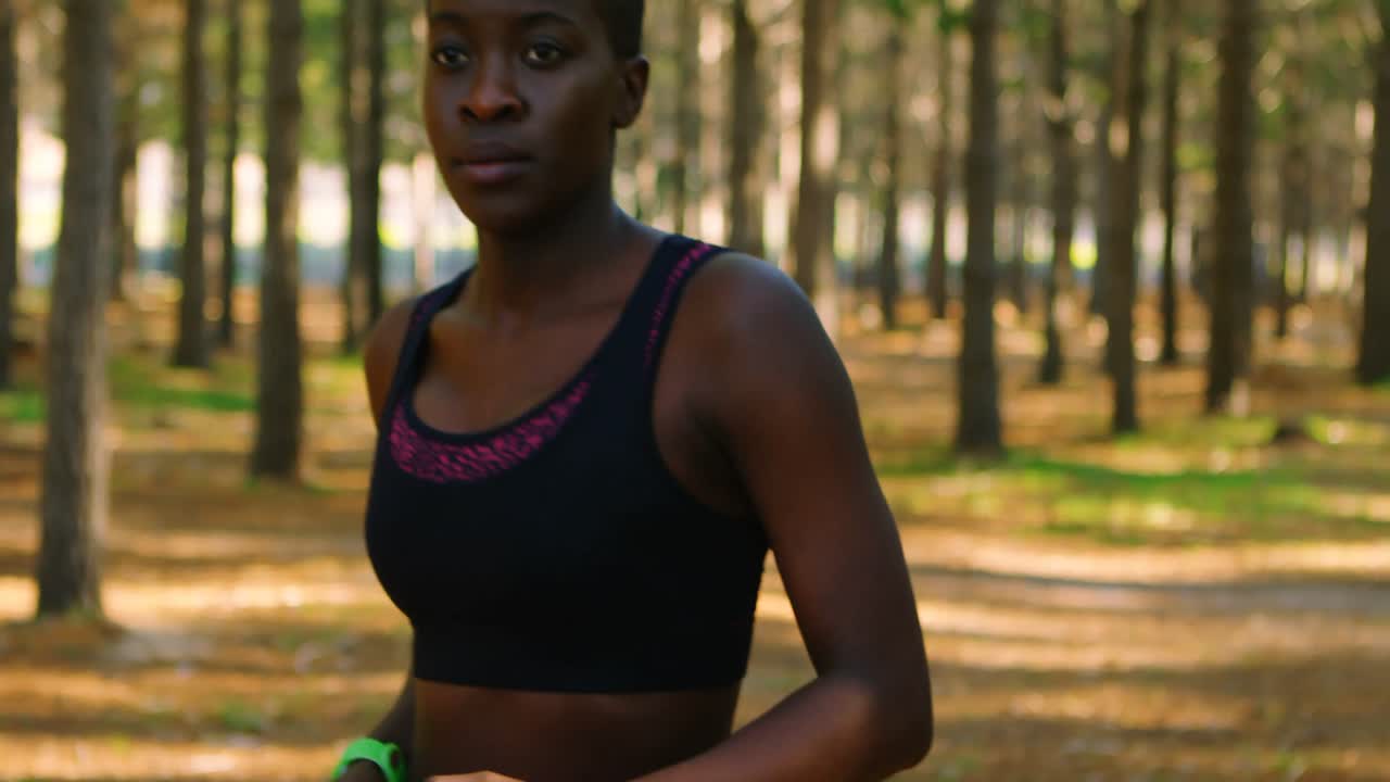 Donna che fa jogging nel bosco 4k