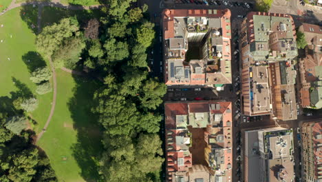 top down aerial shot over the divide between buildings and a park