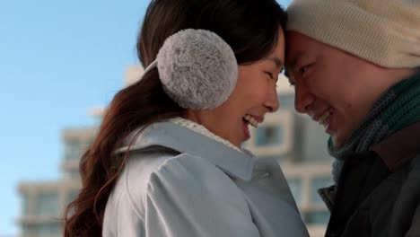 겨울 옷을 입은 사랑하는 아시아 커플이 서로  ⁇ 안고 있습니다.