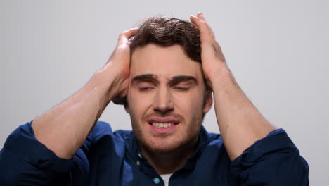 shocked man holding head with hands. scared man with open mouth in studio