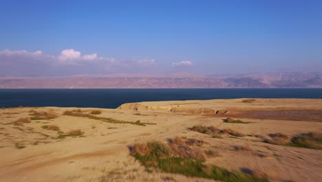 toma aérea del hermoso desierto rojo del mar muerto, vuela hacia el mar, disparada con un dron