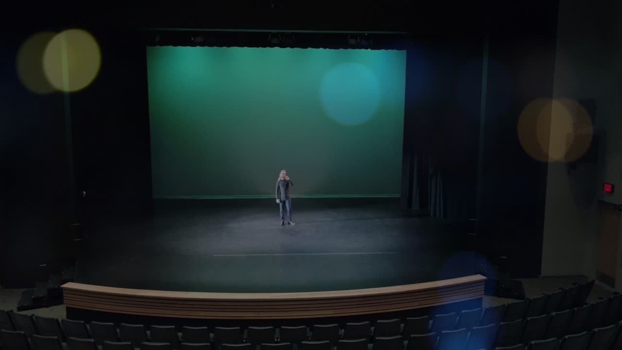 Man delivering business presentation on stage, with animated bar graph and spotlight icons