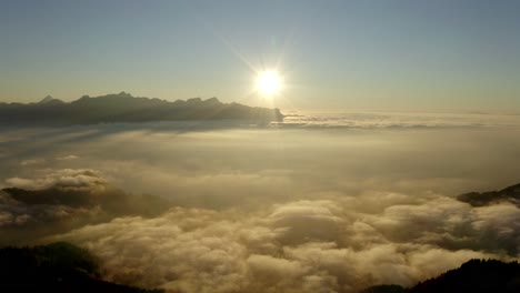 fast overflight above hill and sea of clouds at sunset, switzerland