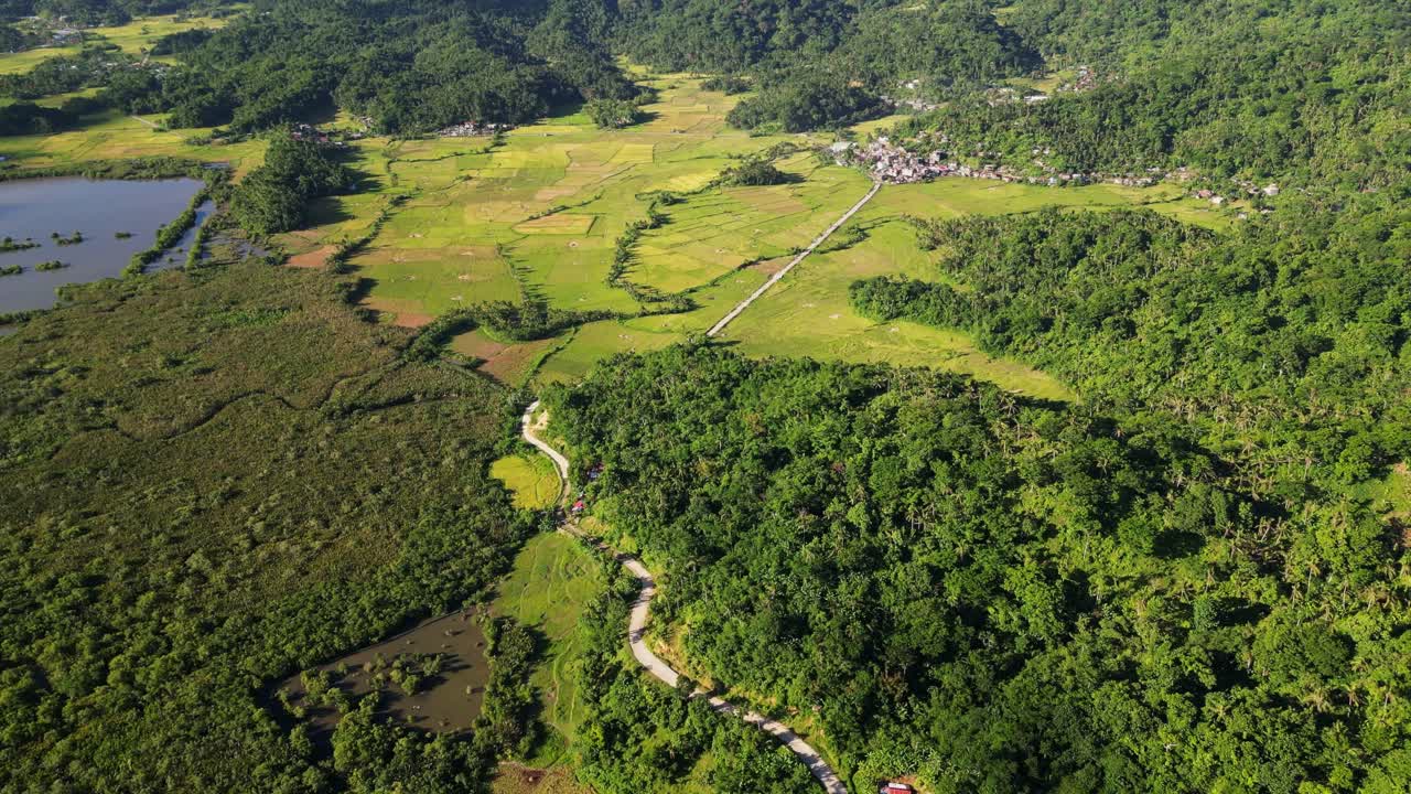 Panoramic view of lush countryside village town, San Roque, with hillside roads and valleys at tropical province Catanduanes, Bicol Philippines.