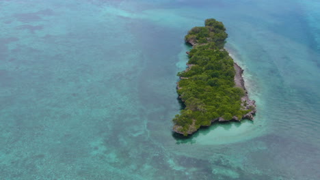 Un-Dron-En-Círculo-Disparó-Alrededor-De-Una-Hermosa-Isla-Arbórea-Rodeada-De-Aguas-Turquesas