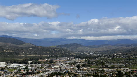 Timelapse-of-clouds-over-city-and-mountains