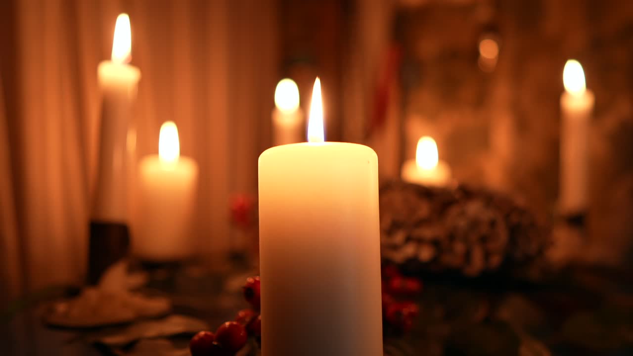 Many candles burning in slow-motion in the dark, romantic vibe or festive decorations for Christmas or a birthday