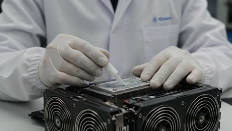 a technician meticulously applies thermal paste to a high-performance graphics card in a clean lab environment, showcasing precision in computer hardware maintenance