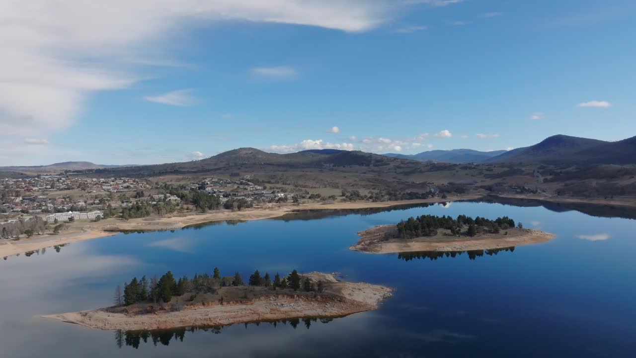 Aerial: Drone shot over Lake Jindabyne pulling out to reveal the islands