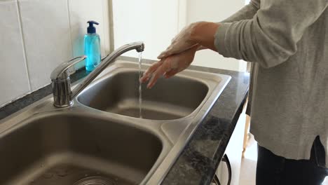 Caucasian-woman-washing-her-hands-with-soap-at-home