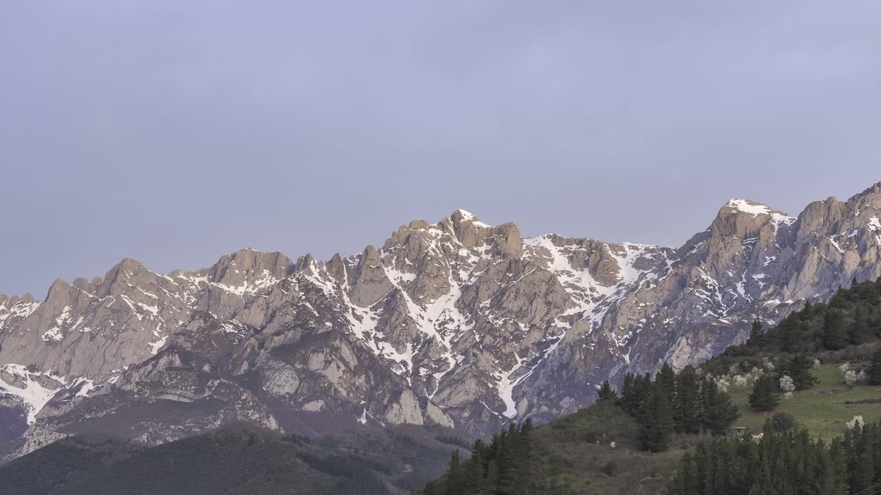 cresta de montaña con árboles bajo un cielo nublado