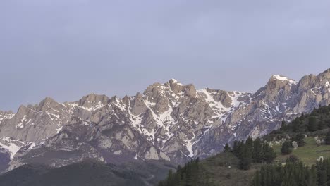 Mountain-ridge-with-trees-under-cloudy-sky