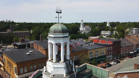Drone-footage-of-the-top-of-Bath-City-Hall-in-Maine,-showing-Streamers-gently-moving-in-the-Breeze