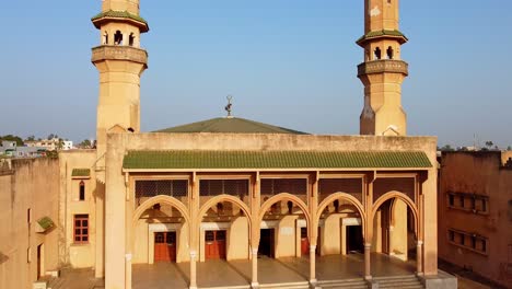 aerial static establishing shot of banjul city's main central mosque facade, king fahd with beautiful minarets