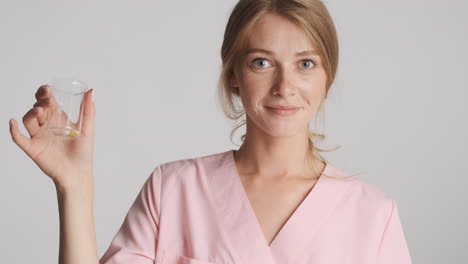 caucasian female doctor holding flask with pills.