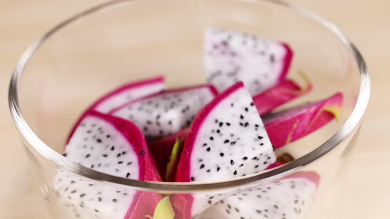 seleccionando a mano piezas de fruta de dragón de un cuenco