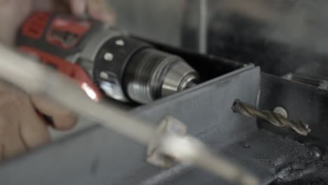 drilling through metal construction frame creating long spiral close up