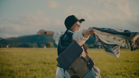 carefree woman with arms outstretched having fun in meadow