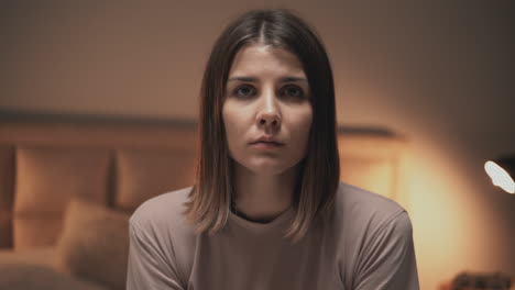 portrait of young serious woman looking at camera indoor