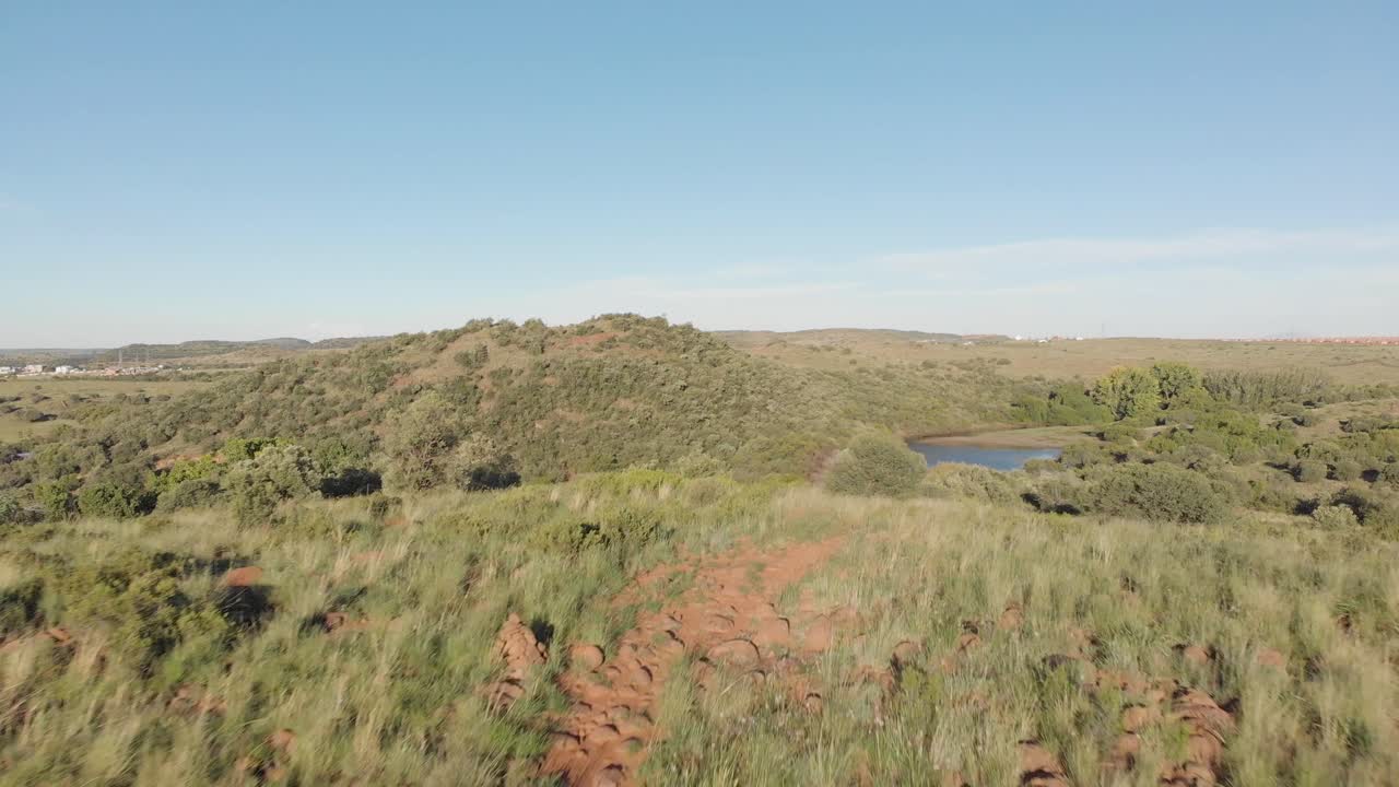 뒤쪽에 주택이 있는 녹색 계곡에 댐을 설치하는 공중 촬영