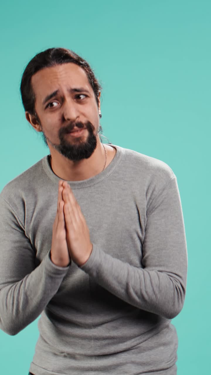 Video verticale. Uomo che giunge le mani implorando, chiedendo un favore
