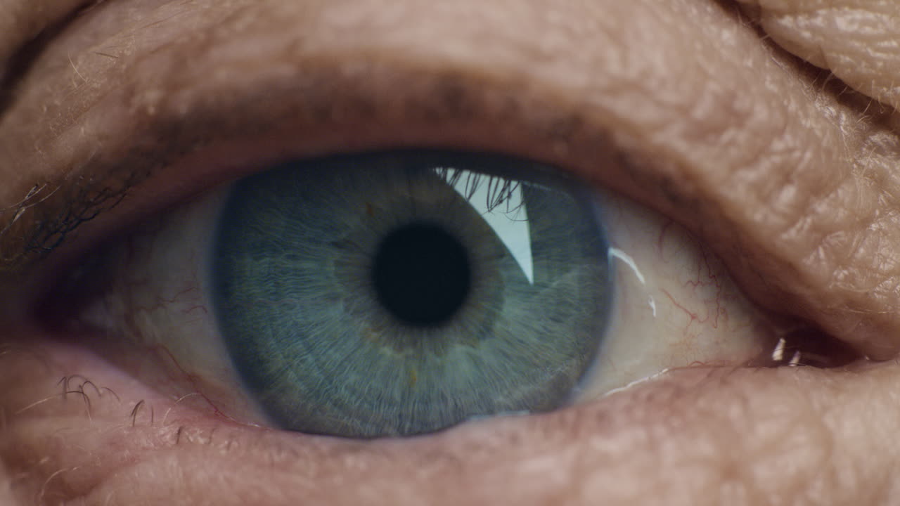 ojo azul de cerca abriéndose mujer vieja parpadeando macro envejecimiento belleza concepto de optometría