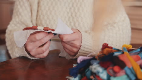 the hands of an unrecognizable woman cross stitching