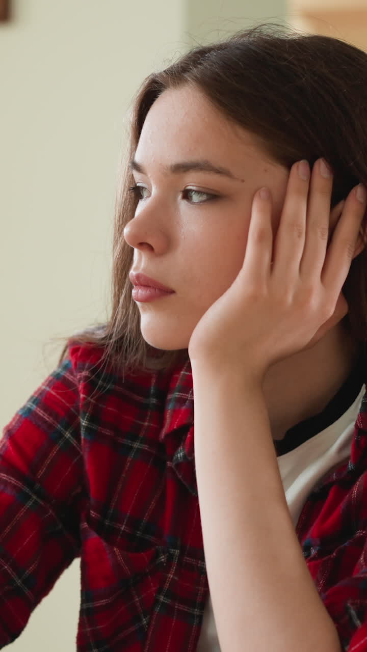 mujer pensativa se apoya en la mano en la mesa en el apartamento. dama morena busca la solución de los problemas de la vida sentada en la cocina. problema de pensamiento obsesivo