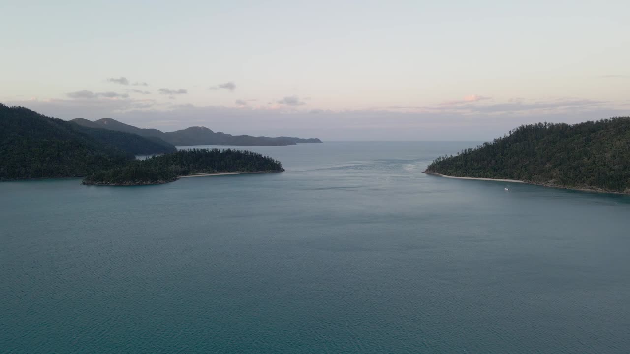whitsundays, qld, australia, at sunset에 있는 후크 통로의 잔잔한 바다에 있는 범선의 먼 전망