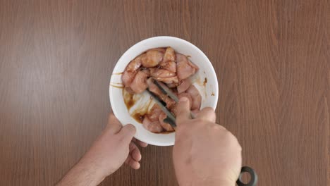 hombre condimentando pollo con salsa de soja