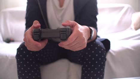 manos de mujer usando la vista de primer plano del gamepad jugando a la consola de video en casa sentada en el sofá