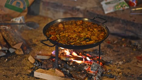 on the road, close up on fire place with typical pan called "paellero" while cooking the classic paella valenciana, almost ready to eat