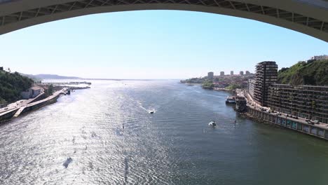 Fly towards and under the Arrábida Bridge in Porto, Portugal
