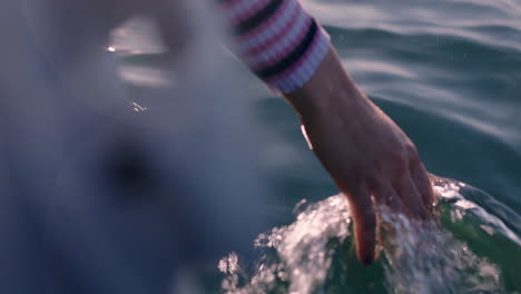 close-up-woman-hand-touching-water-waves-splashing-tourist-enjoying-boat-ride