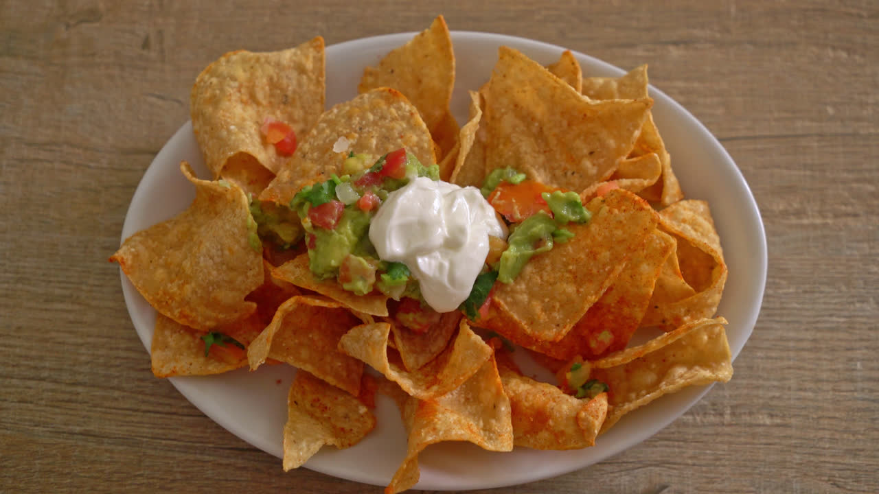 chips de tortilla de nachos mexicanos con jalapeño, guacamole, salsa de tomate y salsa
