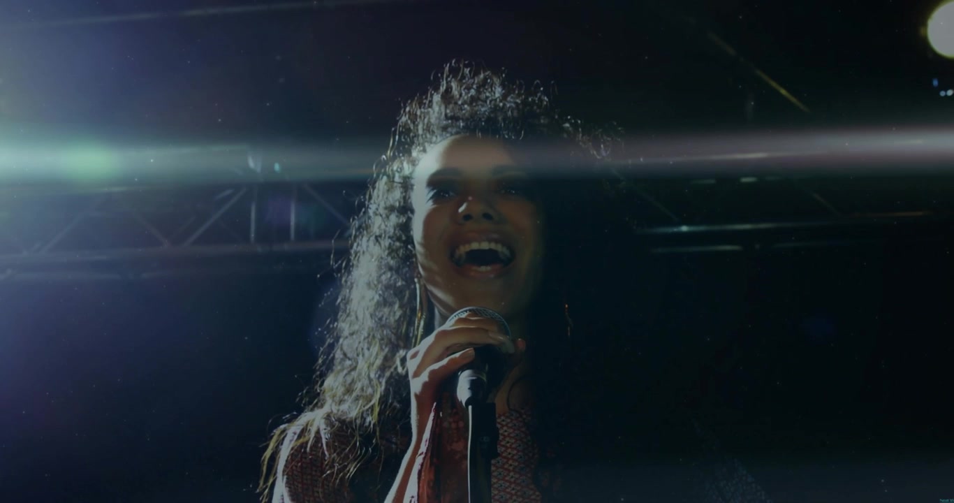 Music vocalist starting note, gripping mic, singing and whipping hair under lights showing emotion
