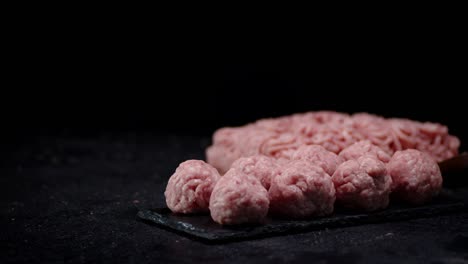 las albóndigas crudas cocidas en una tabla de piedra giran lentamente.