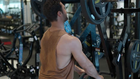 Apuesto-Hombre-Activo-En-El-30-Usando-Entrenamiento-De-Músculos-De-Lat-Bajo-En-Una-Máquina-De-Fila-Sentada-En-El-Gimnasio