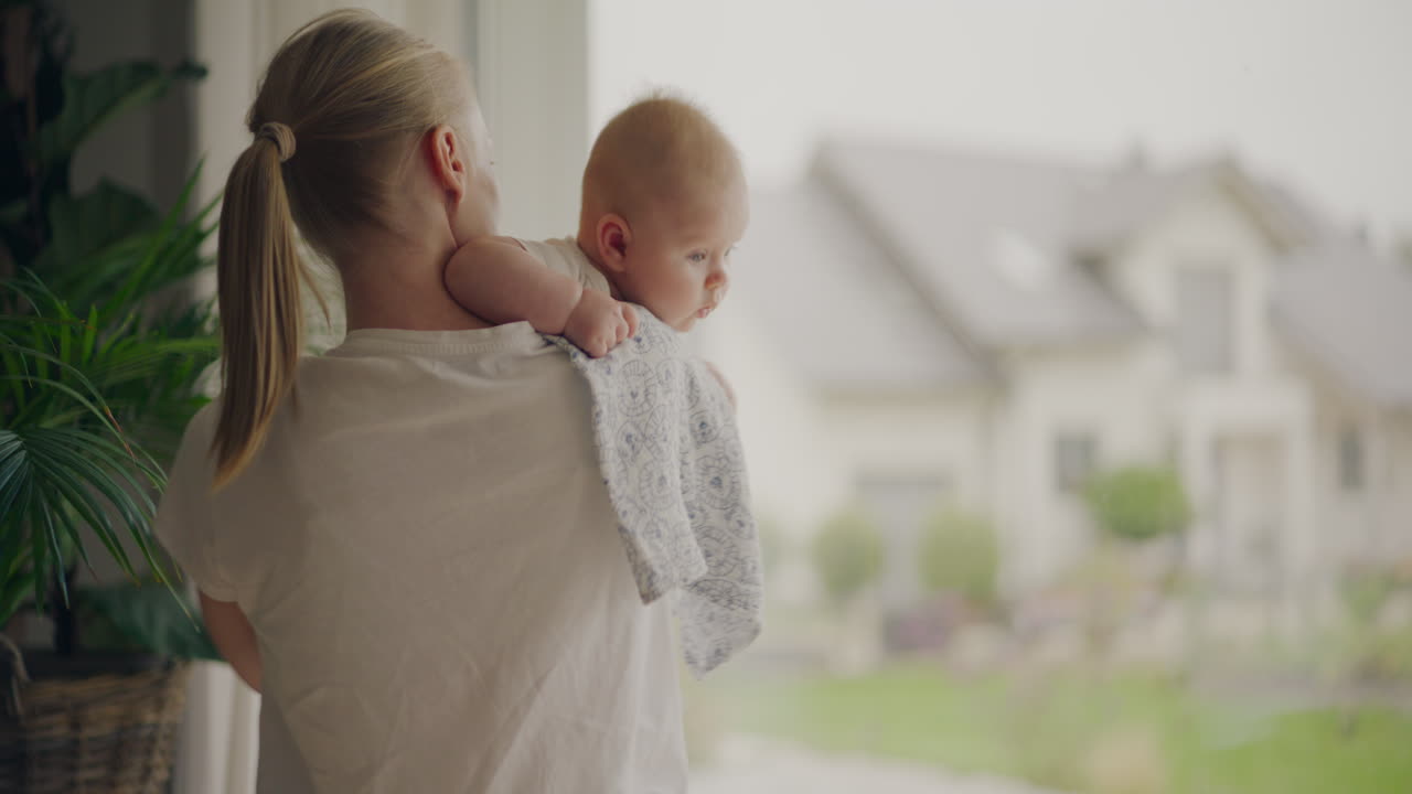 Mother and baby looking out window