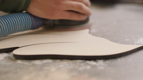 a carpenter grinds a piece of wood, plywood product made on a cnc laser machine with a grinder