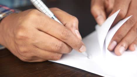 person writing on a piece of paper