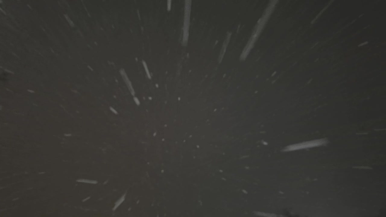 Falling down real snowflakes, heavy snow, snowstorm weather, shot on black background, matte, wide angle, seamlessly looped animation, isolated, perfect for digital composition, post-production.