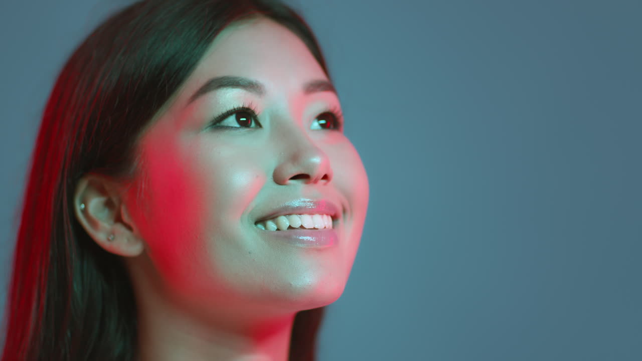 Portrait of a Smiling Asian Woman Under Neon Light