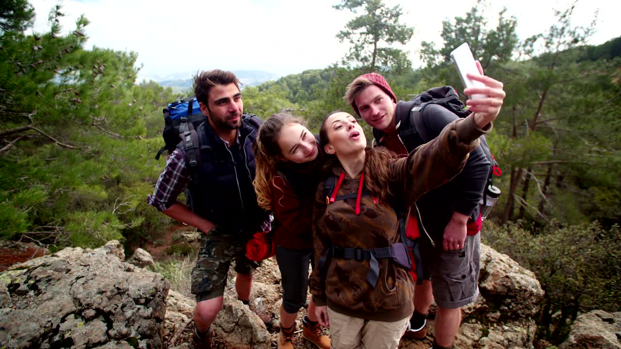 Young hikers couples taking a selfie on a mountain peak