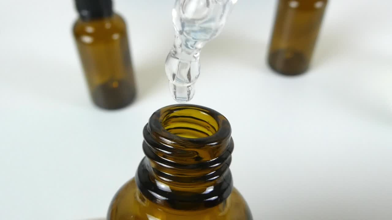 A captivating macro video showcasing a cosmetic serum dripping in slow motion, emphasizing its silky texture and transparency.