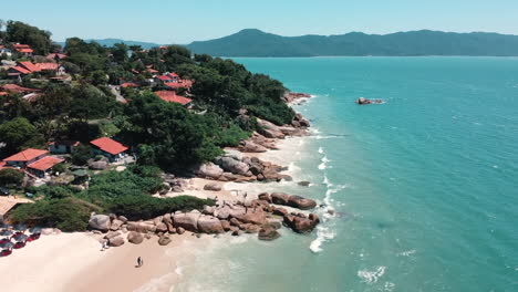 una escena idílica con casas, rocas y una playa azul prístina, una mezcla armoniosa de vida costera y belleza natural