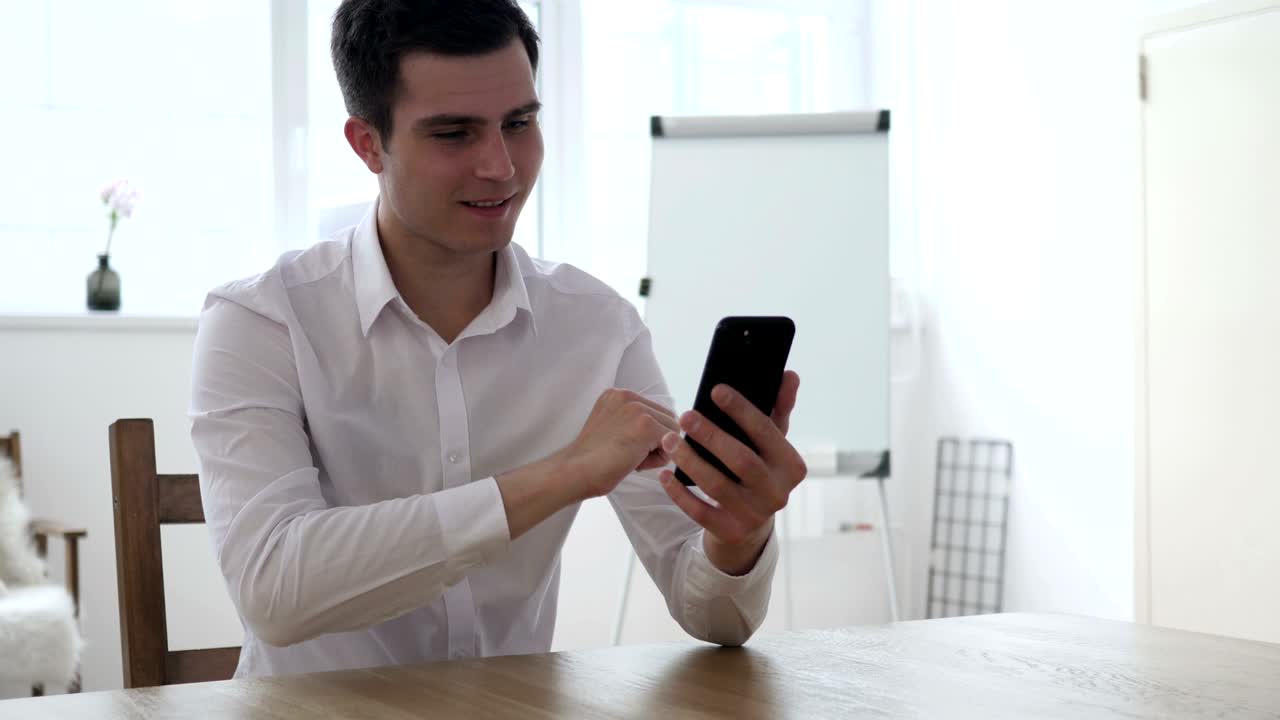 hombre que usa el teléfono inteligente y reacciona al éxito financiero