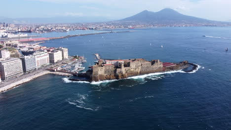 castel dell'ovo in the gulf of naples backdropped by mount vesuvius in naples, italy