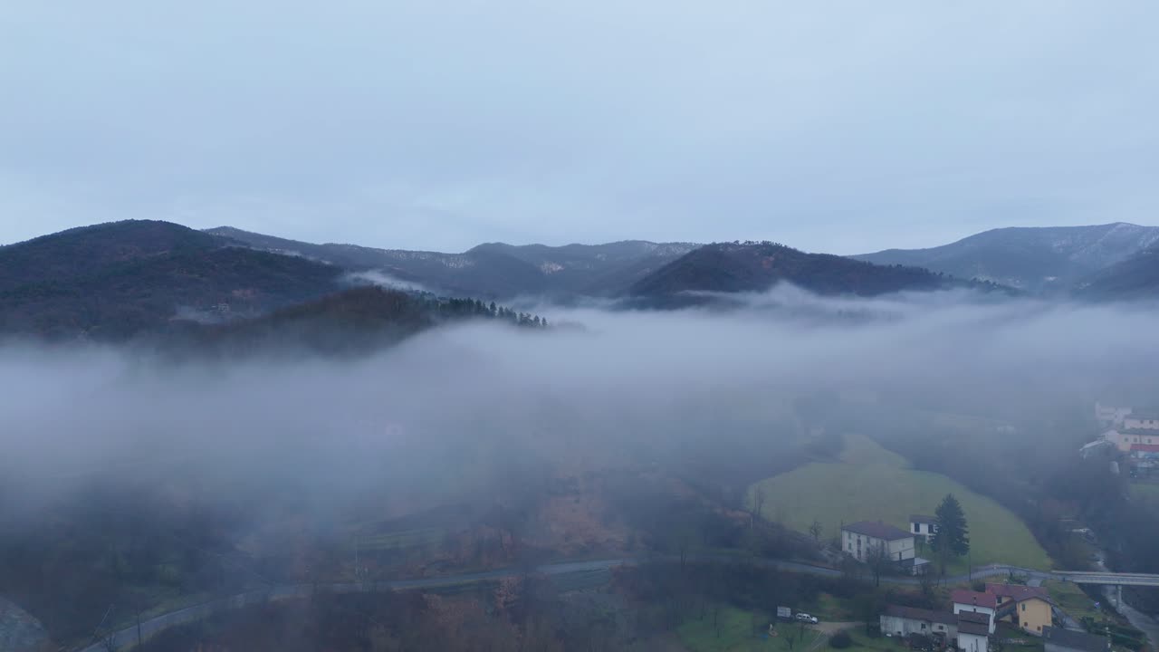 언덕이 많은 시골 풍경 위에 구름과 안개 구름이 가득 차 있습니다.