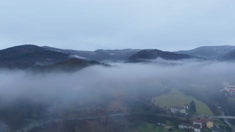 overcast bleak sky and mist cloud over hilly countryside landscape